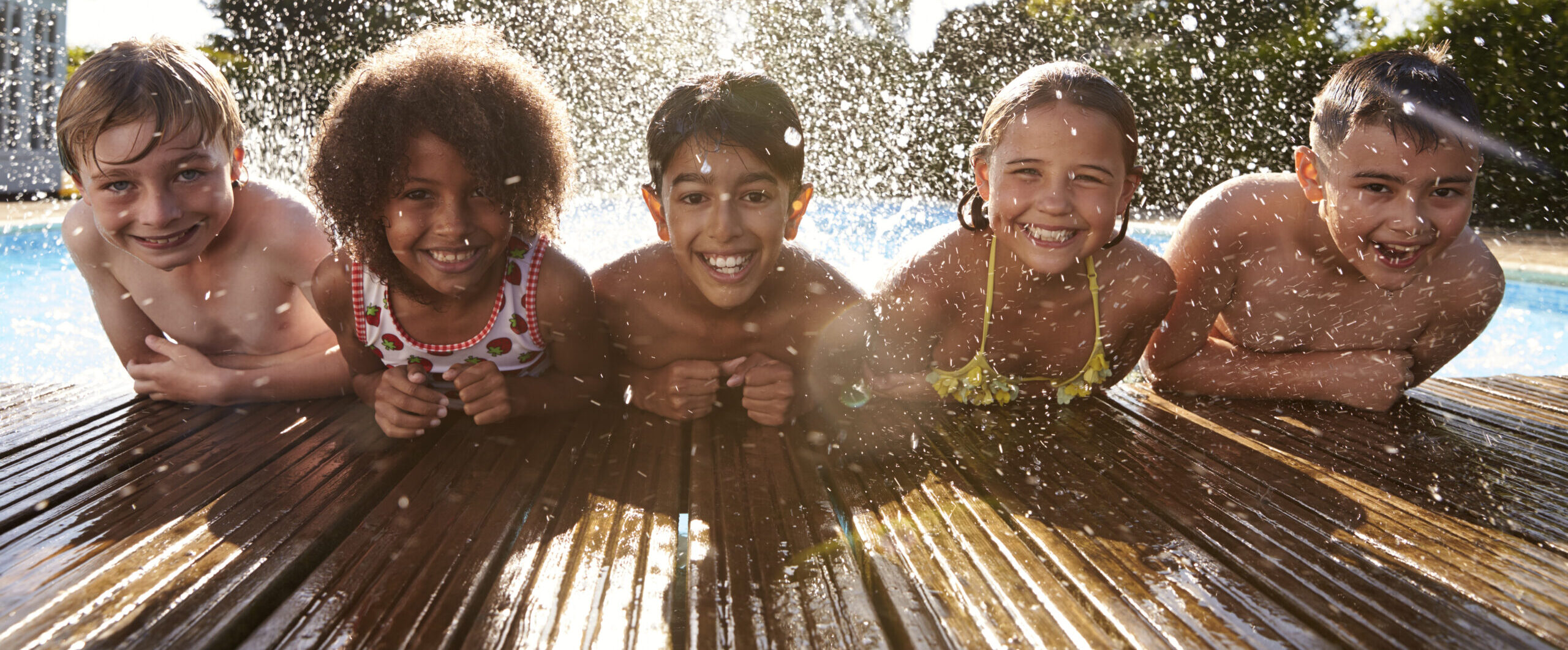 Portrait Of Children Having Fun In Outdoor Swimming Pool